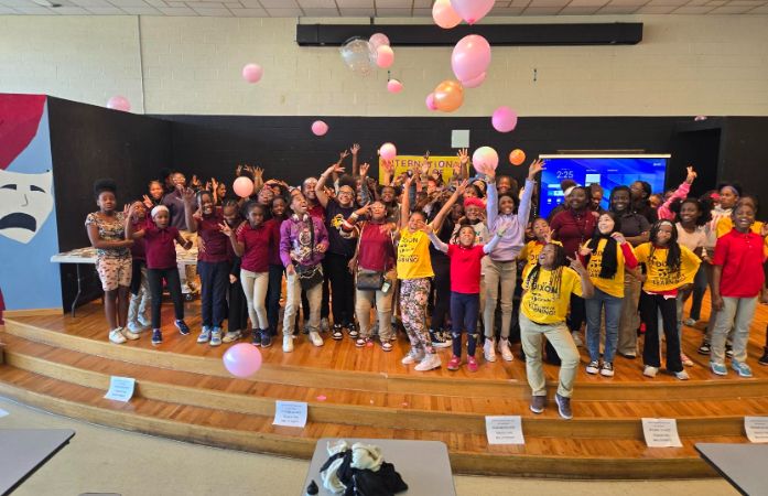 A group of girls taking a picture on stage during Day of the girl